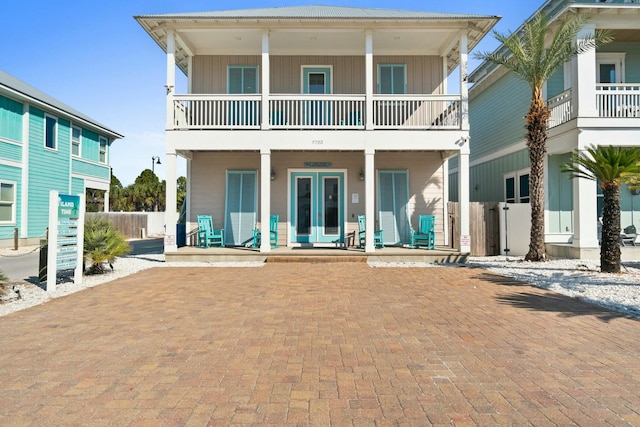 rear view of property featuring covered porch and a balcony