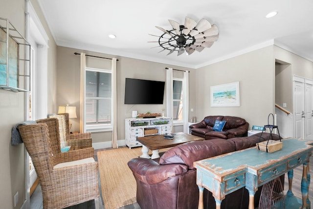 living room featuring plenty of natural light, light wood-type flooring, and ornamental molding