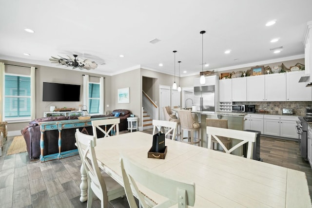 dining room featuring hardwood / wood-style floors, ceiling fan, and crown molding