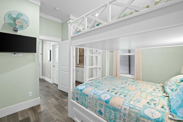 bedroom featuring connected bathroom, dark hardwood / wood-style floors, and ornamental molding