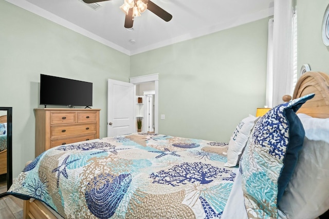 bedroom with ceiling fan, wood-type flooring, and crown molding