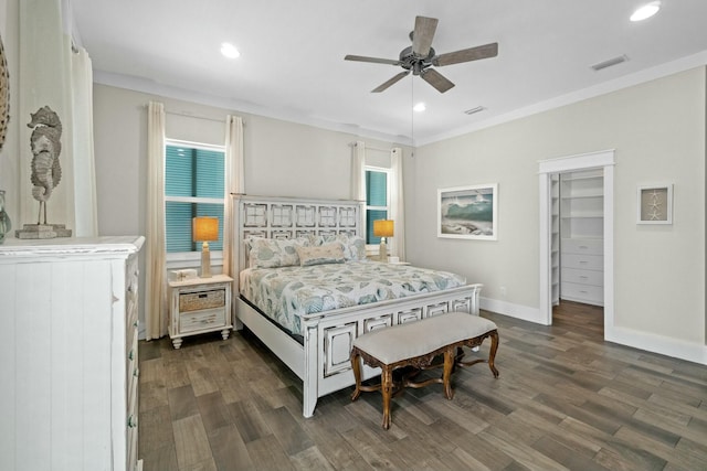 bedroom featuring a walk in closet, ceiling fan, a closet, and dark wood-type flooring