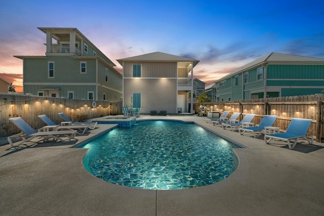 pool at dusk with a patio