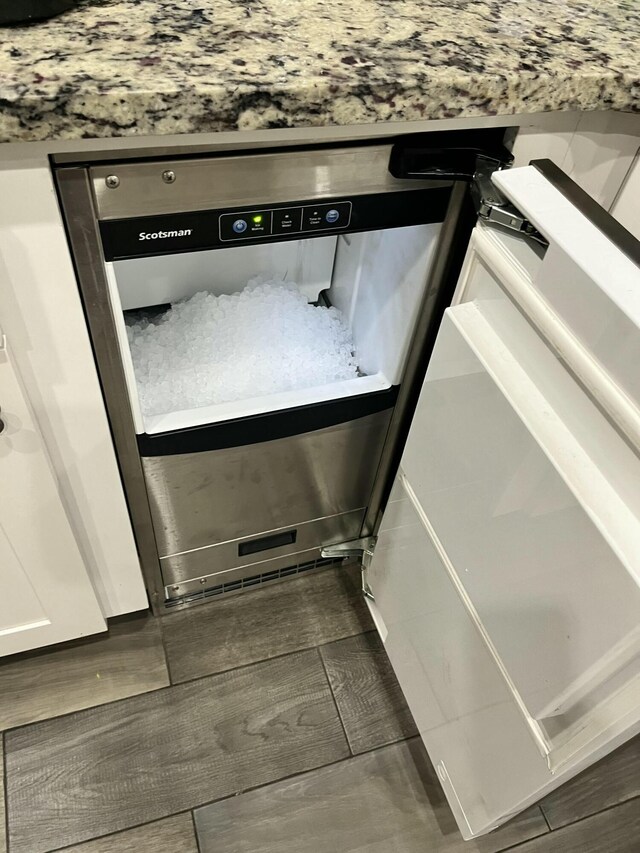 details with white cabinets and dark wood-type flooring