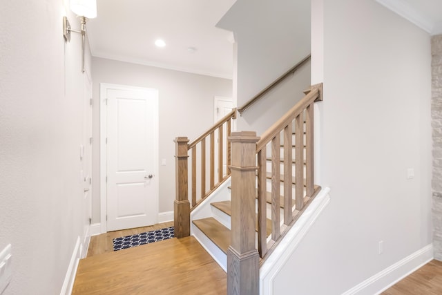 stairway featuring wood-type flooring and ornamental molding