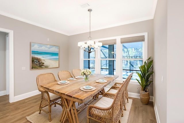 dining area featuring hardwood / wood-style floors, a chandelier, and ornamental molding