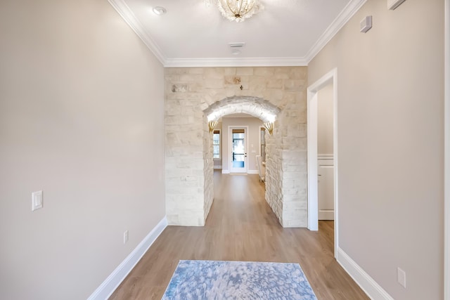 hallway with light hardwood / wood-style flooring and ornamental molding