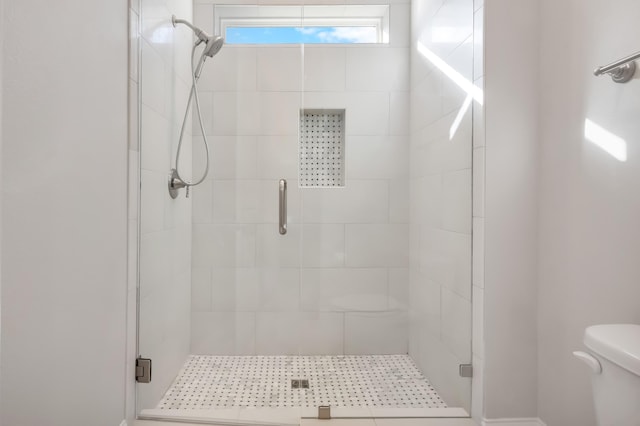 bathroom featuring walk in shower and toilet