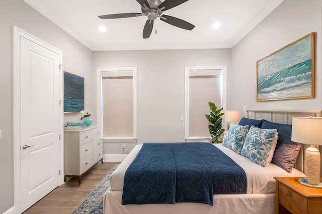 bedroom with ceiling fan, crown molding, and hardwood / wood-style flooring