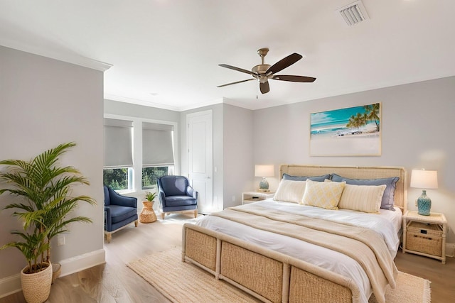 bedroom featuring ceiling fan, crown molding, and hardwood / wood-style flooring