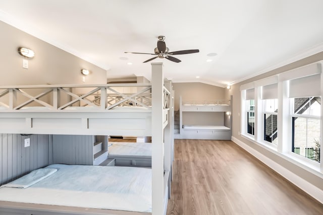 bedroom with wood-type flooring, crown molding, ceiling fan, and lofted ceiling