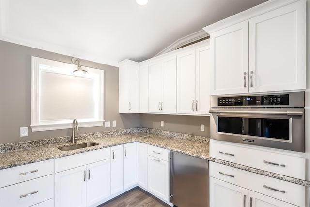 kitchen with lofted ceiling, white cabinets, sink, hardwood / wood-style flooring, and stainless steel appliances