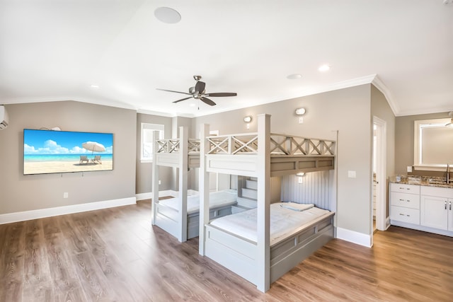 unfurnished bedroom with ceiling fan, light hardwood / wood-style flooring, a wall mounted AC, vaulted ceiling, and ornamental molding