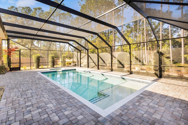 view of pool featuring glass enclosure and a patio