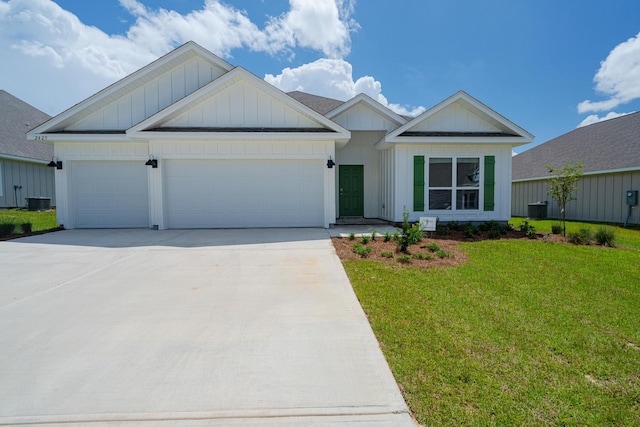 view of front facade with a front yard, a garage, and central air condition unit