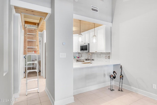 kitchen with pendant lighting, decorative backsplash, appliances with stainless steel finishes, white cabinetry, and wood ceiling