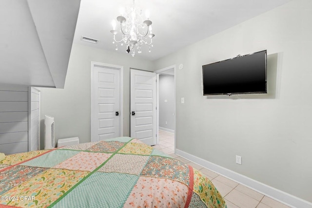 tiled bedroom featuring an inviting chandelier