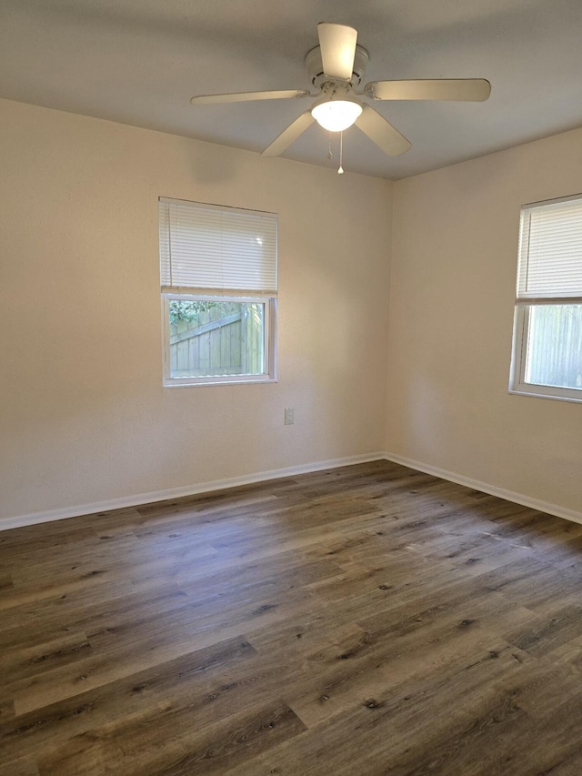 unfurnished room featuring dark hardwood / wood-style floors, a healthy amount of sunlight, and ceiling fan