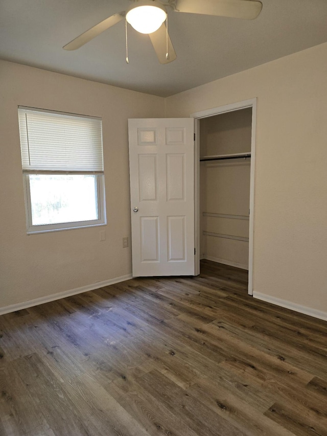 unfurnished bedroom featuring ceiling fan, a closet, and dark wood-type flooring