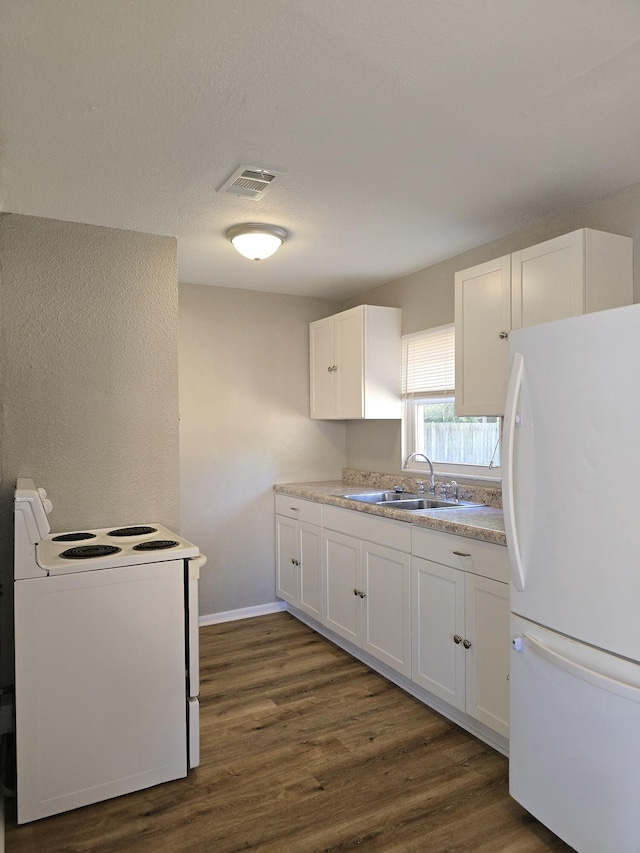 kitchen with dark hardwood / wood-style floors, white cabinetry, white appliances, and sink