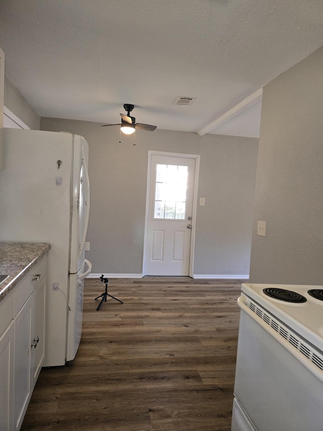 kitchen featuring a textured ceiling, white appliances, ceiling fan, dark wood-type flooring, and white cabinetry