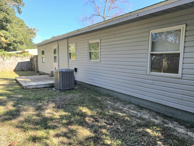 rear view of property featuring central AC unit and a yard