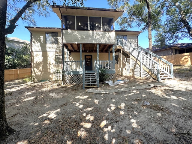 rear view of house featuring a sunroom