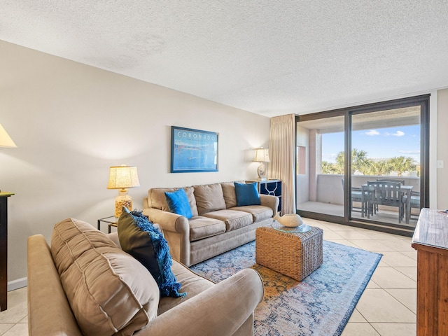 living room featuring light tile patterned floors, a textured ceiling, and a wall of windows