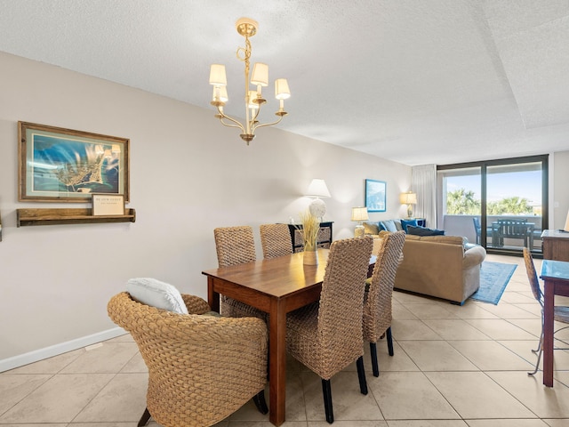 dining room with a notable chandelier, a wall of windows, a textured ceiling, and light tile patterned floors