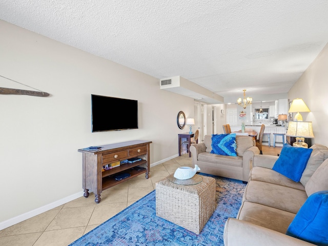 tiled living room featuring a textured ceiling and an inviting chandelier