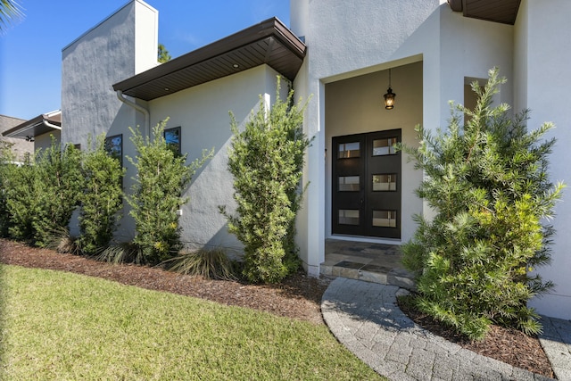 view of exterior entry featuring a yard