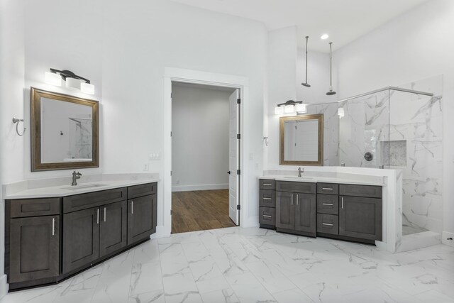 bathroom with a high ceiling, vanity, and a tile shower