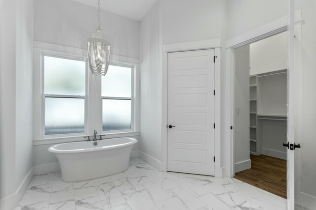 bathroom with a chandelier and a bathing tub