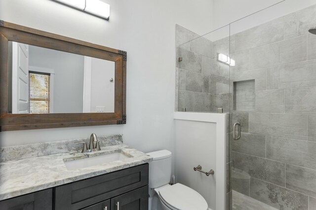 bathroom with vanity, toilet, and a shower with shower door