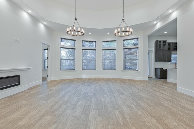 unfurnished living room featuring light hardwood / wood-style floors and a chandelier