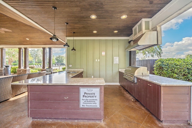 kitchen with pendant lighting, sink, a large island with sink, and wood ceiling