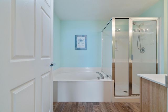 bathroom featuring wood-type flooring, vanity, and separate shower and tub