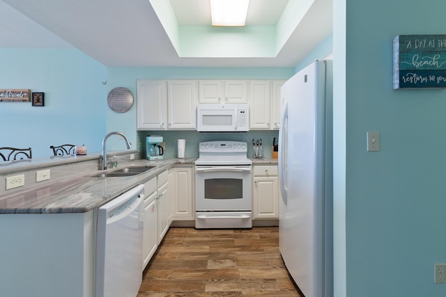 kitchen featuring kitchen peninsula, white cabinetry, sink, and white appliances