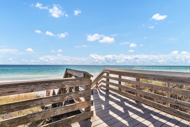 surrounding community featuring a water view and a beach view