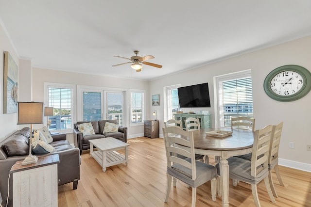 dining room with ceiling fan, a healthy amount of sunlight, and light wood-type flooring