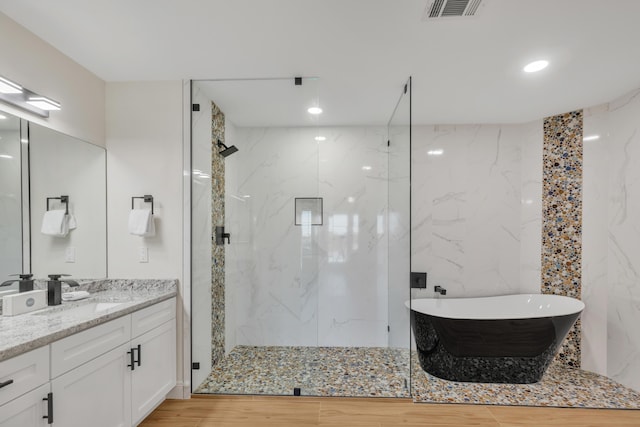 bathroom featuring vanity, separate shower and tub, and tile walls