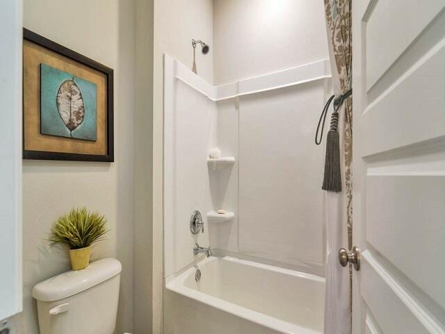 bathroom featuring shower / bathtub combination and toilet