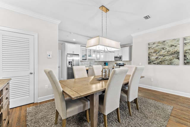 dining room with dark hardwood / wood-style floors and ornamental molding