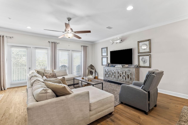 living room featuring wood-type flooring, ceiling fan, and crown molding