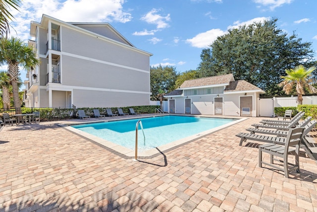 view of swimming pool with an outbuilding and a patio