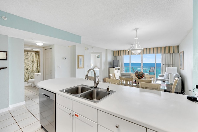 kitchen featuring stainless steel dishwasher, a textured ceiling, sink, decorative light fixtures, and white cabinets