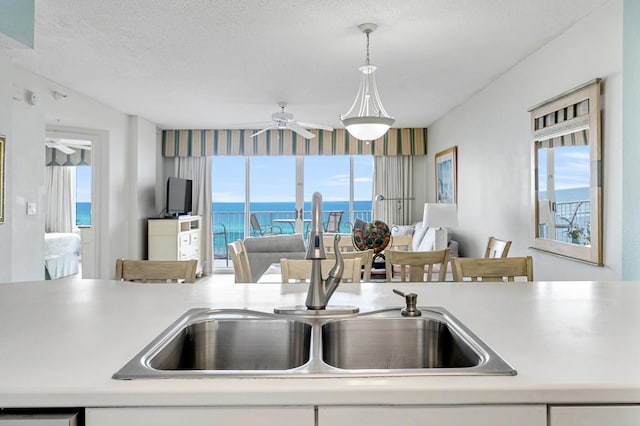 kitchen featuring decorative light fixtures, a textured ceiling, and a wealth of natural light