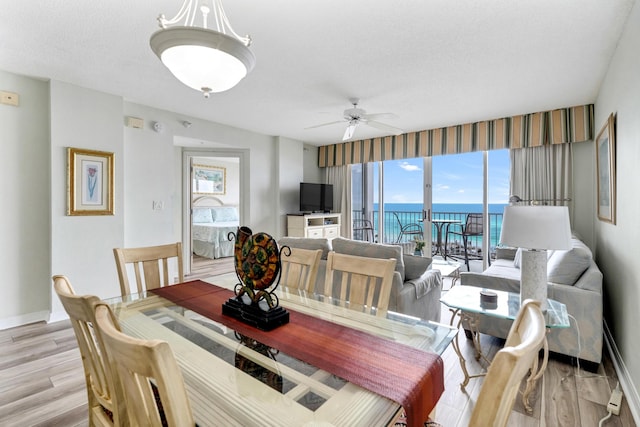 dining area featuring ceiling fan, light hardwood / wood-style floors, and a textured ceiling