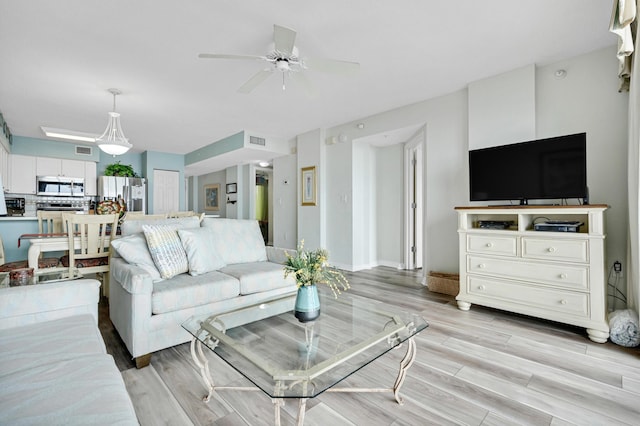 living room featuring ceiling fan and light hardwood / wood-style floors