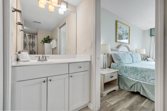 bathroom with a textured ceiling, vanity, and hardwood / wood-style flooring